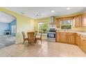 Bright kitchen with wooden cabinets, stainless steel appliances, and adjacent breakfast nook area at 1730 Birmingham Ave, Daytona Beach, FL 32117