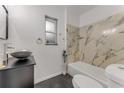 Modern bathroom boasting marble tile wall, sleek vanity, and vessel sink, providing a stylish and functional space at 182 Grove St, Ormond Beach, FL 32174