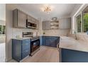 Updated kitchen showcasing two-tone cabinets, stainless steel appliances, white marble-look countertops, and a window view at 182 Grove St, Ormond Beach, FL 32174