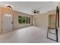 Inviting living room featuring light, modern flooring, a ceiling fan, and natural light from a large window at 182 Grove St, Ormond Beach, FL 32174