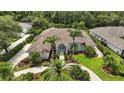 A bird's eye view of this beautiful property, landscaped yard, circular drive, and tile roof, surrounded by lush greenery at 19 Tomoka Cove Way, Ormond Beach, FL 32174