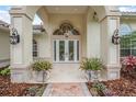 Stately home entry with grand doors, elegant lighting, and manicured planters at 19 Tomoka Cove Way, Ormond Beach, FL 32174