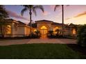 Charming home featuring decorative front doors with arched window and manicured landscaping at dusk at 19 Tomoka Cove Way, Ormond Beach, FL 32174