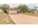 Charming single-story home with brick driveway with mature trees providing shade at 198 Heather Lane Dr, Deltona, FL 32738