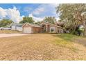 Charming single-story home with a brick driveway and well-maintained lawn and mature trees at 198 Heather Lane Dr, Deltona, FL 32738