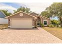 Charming single-story home with a brick driveway and well-maintained lawn and mature trees at 198 Heather Lane Dr, Deltona, FL 32738