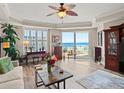 Bright living room with ocean view, featuring a ceiling fan, tile flooring, and sliding doors to the balcony at 2403 S Atlantic Ave # 410, Daytona Beach, FL 32118