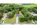 Aerial view of property with red arrow indicating location, surrounded by lush greenery and a beautiful treeline at 2455 Whooping Crane Dr, De Leon Springs, FL 32130