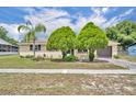 Charming single-story home featuring a well-maintained lawn and mature trees under a blue sky at 2468 Kimberly Dr, Deltona, FL 32738