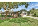 Beautifully landscaped front yard with mature trees and a brick home at 2480 S Glen Eagles Dr, Deland, FL 32724