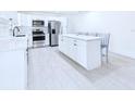 Bright kitchen featuring an island with seating, stainless steel appliances, and white cabinets at 2526 Victory Palm Dr, Edgewater, FL 32141