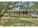 Welcoming single-story home showcasing a delightful screened-in porch and a well-manicured front yard at 25305 Mardon Cir, Paisley, FL 32767