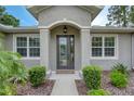 Close-up of home's entrance showing the arched door and surrounding green landscaping at 3428 Saltee Cir, Ormond Beach, FL 32174