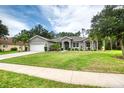 Beautiful single-story home with a green lawn and professional landscaping at 3428 Saltee Cir, Ormond Beach, FL 32174