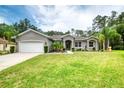 Inviting home with a well-kept lawn, lush landscaping, and attached two-car garage at 3428 Saltee Cir, Ormond Beach, FL 32174