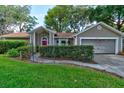 Charming single-story home with mature landscaping, a red front door, and an attached two-car garage at 4204 Rocky Ridge Pl, Sanford, FL 32773