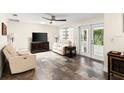 Cozy living room with white leather furniture, stylish flooring, and French doors leading to the outdoors at 4638 Saxon Dr, New Smyrna Beach, FL 32169