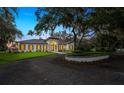 A picturesque, single-story home is framed by mature oak trees and a manicured front lawn at 4885 State Road 11, De Leon Springs, FL 32130