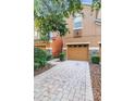 Two-story townhome with a brick-paved driveway, complimented by stone accents and tasteful landscaping at 5060 Cypress Branch Pt, Oviedo, FL 32765