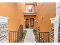 Inviting front entrance with an orange-colored facade, well-kept walkway and decorative gate at 5060 Cypress Branch Pt, Oviedo, FL 32765