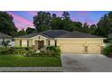 Charming single-story home at twilight, showcasing its inviting curb appeal and convenient three-car garage at 508 Morgan Wood Dr, Deland, FL 32724