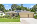 Attractive single-story home with a three-car garage, solar panels and meticulous landscaping enhancing its curb appeal at 508 Morgan Wood Dr, Deland, FL 32724