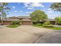 A well-maintained property with lush landscaping and a large driveway leading to multiple garages at 510 Sandy Bluff Trl, Deland, FL 32724