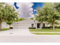 Inviting single-story home with manicured lawn, tidy landscaping, and a spacious two-car driveway at 565 Morgan Wood Dr, Deland, FL 32724