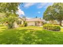 Charming home exterior with a lush green lawn and mature landscaping under a bright sky at 212 Mallard Ln, Daytona Beach, FL 32119