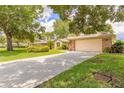 View of the home's front exterior showing the driveway, manicured lawn, and mature landscaping at 212 Mallard Ln, Daytona Beach, FL 32119