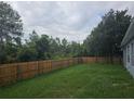 A fully fenced back yard with a large grassy area, perfect for entertaining at 3339 Croton Ave, Deltona, FL 32738