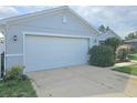 A large two car garage with a concrete drive and manicured bushes at 3339 Croton Ave, Deltona, FL 32738