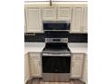 Kitchen boasting new stainless steel oven and microwave above, with cream colored cabinets at 79 Cypress Pond Rd # 79, Port Orange, FL 32128