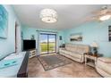 Comfortable living room with tile floors, modern lighting, and a sliding glass door to the outdoors at 2390 Ocean Shore Blvd # 1040, Ormond Beach, FL 32176