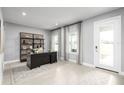 Bright home office with a large desk, built-in shelving, and natural light at 1202 Whispering Ln, Minneola, FL 34715