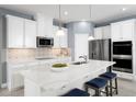 Modern kitchen boasts white cabinets, stainless steel appliances, quartz countertops, and backsplash at 5043 Bear Lake Loop, Deland, FL 32724