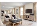 Open-concept living room showcasing neutral decor, a media center and connection to the kitchen at 5047 Bear Lake Loop, Deland, FL 32724