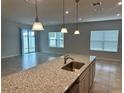 Kitchen island with granite countertops and view into Gathering room at 260 Crossings Ave, St Cloud, FL 34771