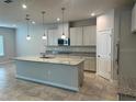 Island kitchen with granite countertops and stainless steel appliances at 260 Crossings Ave, St Cloud, FL 34771