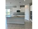Modern kitchen featuring white cabinets, granite countertops, and stainless steel appliances at 380 Crossings Ave, St Cloud, FL 34771