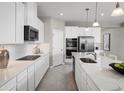 Modern kitchen with white cabinets, quartz counters, and stainless steel appliances at 3042 Aibonito Cir, Clermont, FL 34711