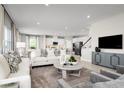 Open living space with white sofas, a large TV, and kitchen views at 3042 Aibonito Cir, Clermont, FL 34711