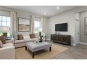 Spacious living room with beige sofa, ottoman, and large TV at 3744 Sky Mountain Aly, Apopka, FL 32712