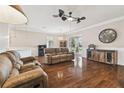 This expansive living room features hardwood floors, a ceiling fan, and comfortable seating, perfect for relaxing or entertaining at 8320 Sw 82Nd Loop, Ocala, FL 34481