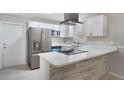 Modern kitchen with stainless steel appliances, white cabinetry, and stone countertops and backsplash at 1360 10Th Ne Ct, Winter Haven, FL 33881