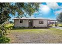 Charming single-story home with white brick and a covered carport set against a bright sky backdrop at 5030 Alderman Rd, Lakeland, FL 33810