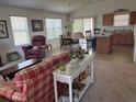 Bright living room featuring neutral carpet, a comfortable seating arrangement, and an open layout at 2595 Edenville Path, The Villages, FL 32162
