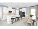 Modern kitchen with white cabinets, stainless steel appliances, and a center island with seating at 5008 Balsam Falls Rd, Deland, FL 32724