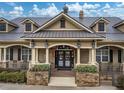 Community clubhouse featuring stone accents, a covered porch, and beautifully landscaped entrance at 22004 Belgian Ct, Mount Dora, FL 32757