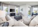 Well-lit living room boasting a large TV, comfortable seating, and picturesque windows offering outdoor views at 1628 Covey Rise Ter, Winter Haven, FL 33884